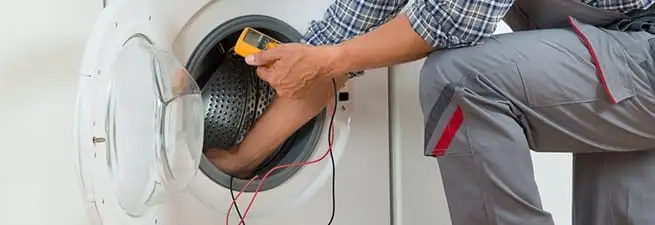 Dryer repair technician inspecting and repairing a clothes dryer in San Jose, CA