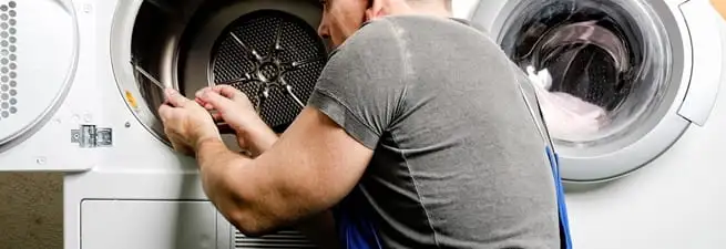 Dryer repair technician fixing a clothes dryer drum in San Jose, CA