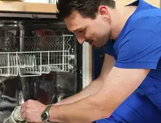 Dishwasher repair technician inspecting and servicing an open dishwasher in San Jose, CA