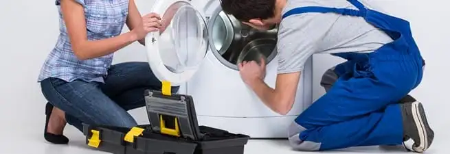Washer repair technician inspecting a front-load washing machine with tools in San Jose, CA