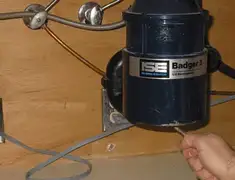 Garbage disposal repair technician tightening the mounting ring under a sink in San Jose, CA