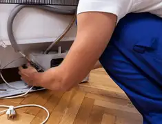 Appliance repair technician fixing refrigerator water line and connections in San Jose, CA