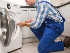 Washing machine repair technician servicing a front-load washer in San Jose, CA