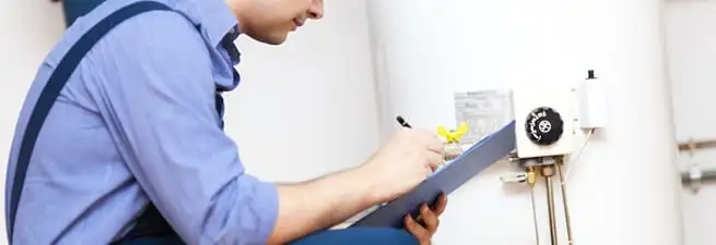 Water heater repair technician inspecting the unit and recording service notes in San Jose, CA