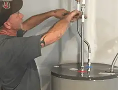 Water heater repair technician tightening supply line connections in San Jose, CA