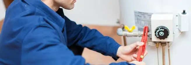 Water heater repair technician adjusting the temperature control and gas valve in San Jose, CA